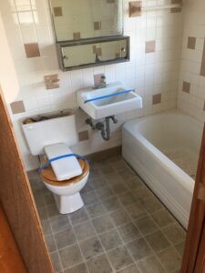 Small bathroom with toilet, sink, and bathtub.