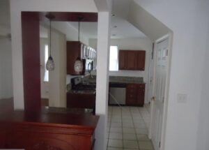 View of a kitchen with wooden cabinets and white appliances.