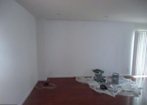 Empty room with painting supplies on the floor.