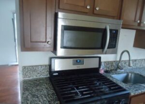 Modern kitchen with stainless steel microwave and gas stove.