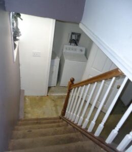 Staircase leading down to a laundry area with washer and dryer.