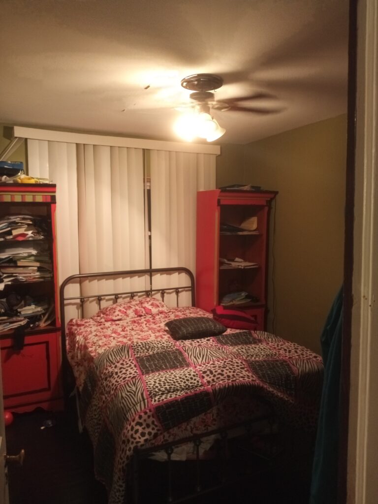 A bedroom with a large bed and a shelf