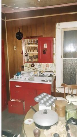 A cluttered kitchen with red cabinets